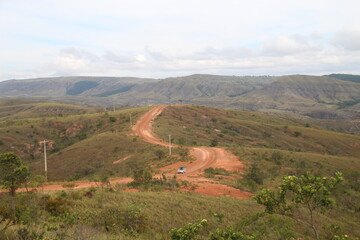 carro em estrada de terra entre montanhas e lavrados no município de uiramutã, roraima