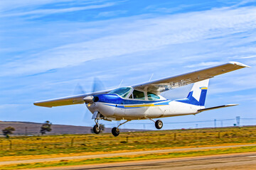 Sleek single engine, high wing, blue and white aircraft taking off from an airstrip in the Western Cape, South Africa
