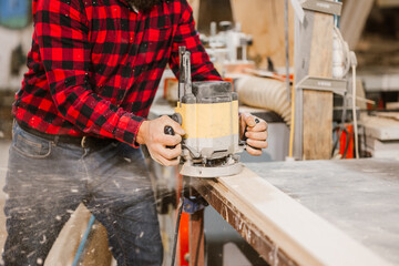 Woodworker Using Router in Workshop
