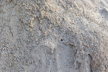 Pile of natural coarse sand with small rocks and pebbles