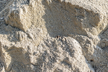 Close-up of natural sand texture with shadows and patterns