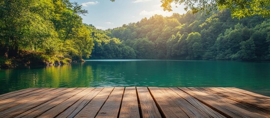 Scenic waterfront view from a wooden dock surrounded by lush green trees and a tranquil blue lake under a bright sunny sky