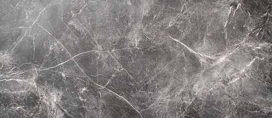 Gray and black textured stone surface with veining and soft light from above creating a polished marble effect suitable for modern interiors