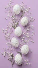 Fototapeta premium Decorative speckled eggs arranged with delicate flowers on a pastel purple background for a spring celebration