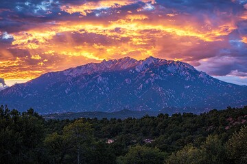 Obraz premium Majestic mountain range under a vibrant sunset sky, showcasing dramatic colors and serene landscape