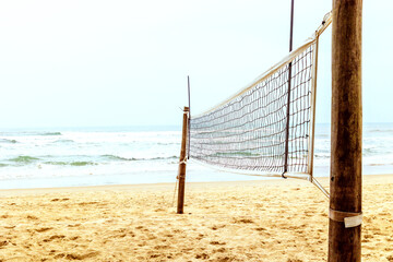 Empty beach volleyball court on a sunny day with a clear ocean view in the background