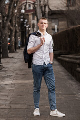 Stylish Young Man Posing in Urban Setting with Casual Outfit