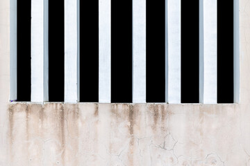 Vertical white bars on weathered wall with cracks and peeling paint