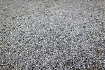 Close-up of grey gravel surface with small stones and textured pattern