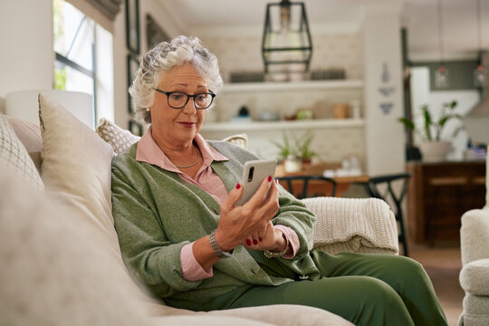 Senior woman using mobile phone at home