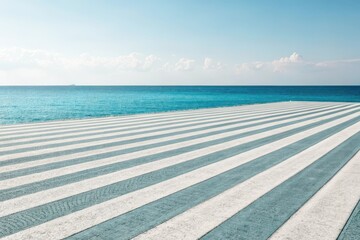 Fototapeta premium Striped coastal promenade extending to a calm ocean horizon under a bright summer sky