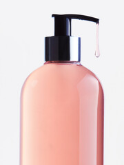 pink cosmetic product in a transparent bottle on a white background