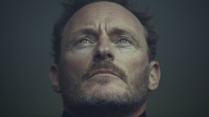 Man gazing upward, contemplative expression, outdoor setting, peaceful background.  Use  Website, blog, article