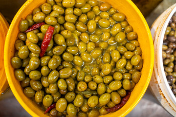 Olives salted with hot pepper in oil for sale at the market.