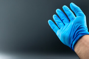 Hands wearing blue gloves isolated on black background