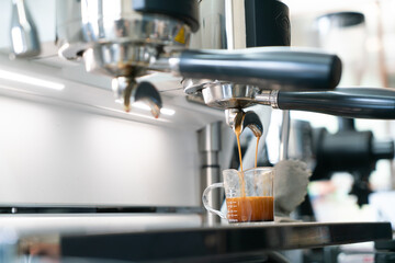 Preparing coffee in coffee shop with professional coffee machine