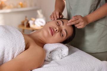 Woman receiving face massage in spa salon