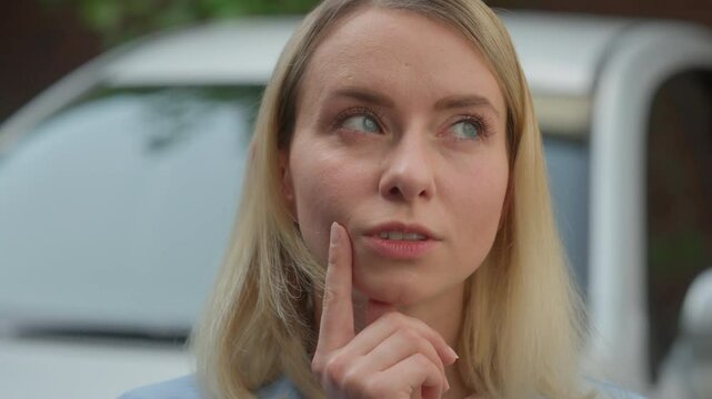 Puzzled contemplative Caucasian woman automobile buyer lady driver think of solution in city ponder car trouble difficulty girl businesswoman brainstorm auto problem consumer female raise finger idea