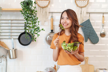 portrait slim asian woman eating vegetables salad,healthy food,vegan,vegetables salad,cooking in...
