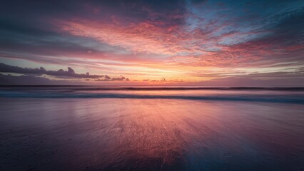 Obraz premium Serene abstract seascape at sunset with warm oranges and pinks blending over calm water reflecting the colorful sky and gentle waves.