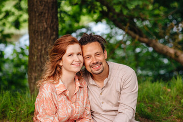 Fototapeta premium Beautiful couple smiling in the park, perfect for themes of love, romance, relationships, happiness and outdoor recreation.