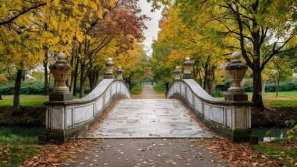 Naklejka premium Autumn morning in a serene park featuring a marble bridge surrounded by vibrant yellow and orange leaves with a soft fog creating a tranquil atmosphere