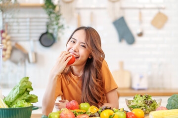 portrait freshy young asian woman having fun in the kitchen,hand holding ripe tomato for cook,healthy food,nutrition,vitamin,beauty,health