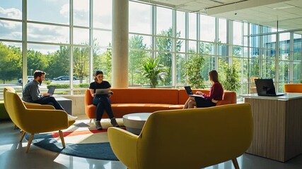 Modern office space with three people engaged in work, surrounded by greenery and natural light