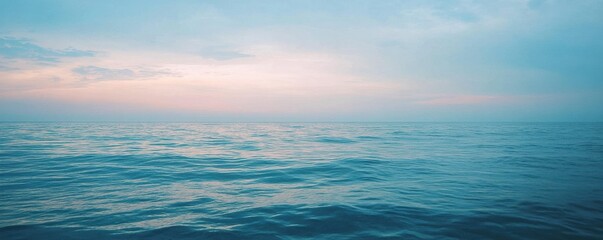 Fototapeta premium Tranquil ocean at sunset with calm waves and pastel sky