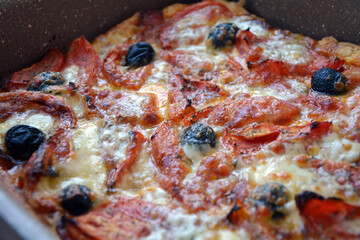 Close-up of a delicious homemade pizza with tomatoes, olives and mozzarella