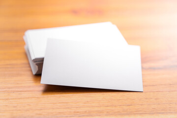 Blank mock up (business card) and cup of coffee on wooden background. Mock up for design