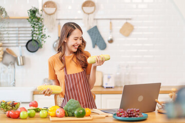 cheerul young asian woman cooking healthy food show on live streaming by laptop online in modern kitchen