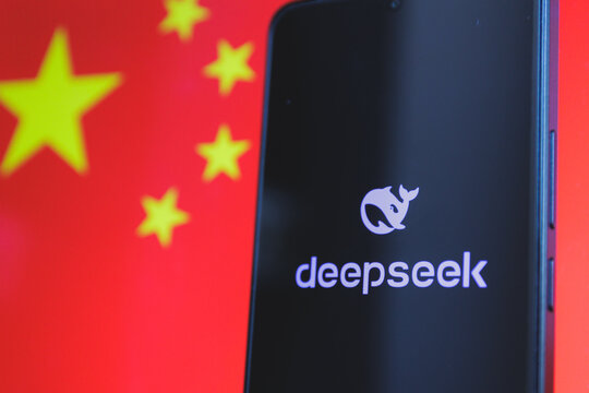 A smartphone displaying the Deepseek logo with the Chinese flag in the background. Growing Chinese technology and artificial intelligence on the global stage
