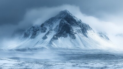 A majestic mountain covered in snow under a cloudy sky.