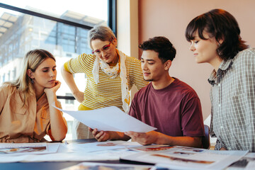 College students and a teacher reviewing feedback on assignments in a classroom setting