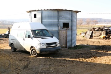 This image showcases a Metal Structure and a Van situated in a picturesque Rural Landscape