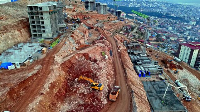 The video shows excavation work at a residential construction site. Excavators are digging and loading materials into a truck. The work reflects foundation preparation and ground leveling stages.