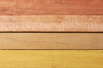 close-up of multiple wooden planks stacked horizontally with different colors, reddish brown to light yellow
