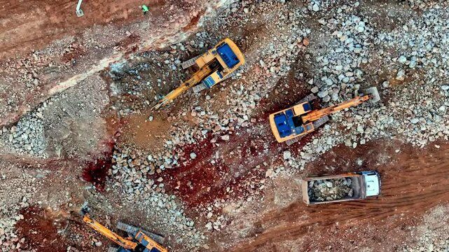 The video shows excavation work at a residential construction site. Excavators are digging and loading materials into a truck. The work reflects foundation preparation and ground leveling stages.