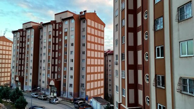 The video shows completed multi-story residential buildings. The structures feature a uniform architectural design, with parking areas and landscaping visible within the residential complex.