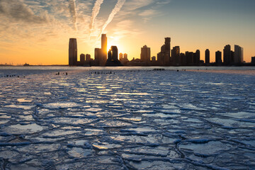 Sunset on the frozen Hudson River with skyline view of Downtown Jersey City skyscrapers (Exchange...