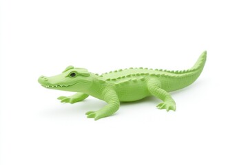 Obraz premium A vibrant green toy crocodile lying on a white surface, showcasing its detailed features and playful design