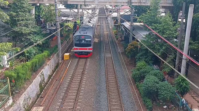 Tebet, Jakarta, Indonesia - January 26, 2025: KAI Commuter line passes over the train tracks towards Manggarai station, South Jakarta.