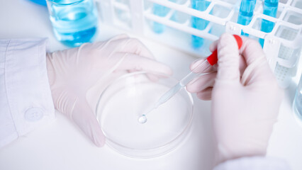 Close-up scientist using pipette drop plate laboratory research chemical chemistry science