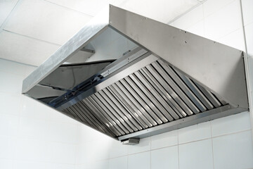 Stainless steel kitchen exhaust hood in modern restaurant kitchen for effective ventilation and smoke removal