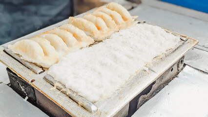 High angle view. The serving process of an authentic Indonesian traditional cake  famously known as Bandros or Gandos. Best served with crystal sugar