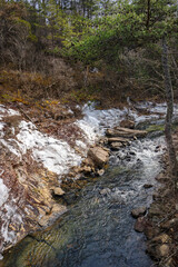 Lula Lake Land Trust, Lookout Mountain, Georgia. A close view of Rock Creek looking away from Lula Lake. The banks of the creek are blanketed in patches of ice.