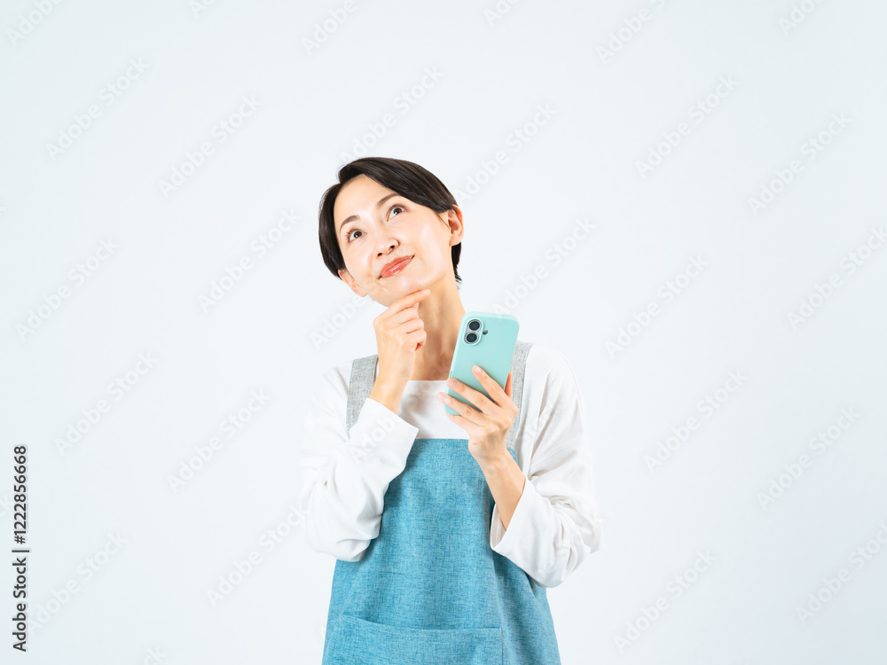Aufkleber スマホ、笑顔、女性、考える、期待、希望、検索、家事、TIPS、時短、スマートフォン、日本人、求人、介護士、料理、レシピ、計画、想像、発想、アイデア、ミドルエイジ、中高年、30代、40代、主婦、ママ、カフェ、飲食店、店員、スポットワーク、スキマバイト、アルバイト、パート、見上げる、コピースペース、広告、イメトレ、ひらめき、夢、ポジティブ、疑問、仕事、エプロン、保育士、保育園、悩む、迷う、問題、メール