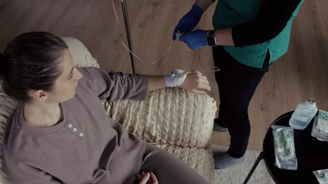 Nurse preparing iv drip for patient at home