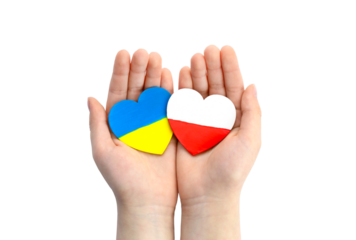 Children's hands hold two hearts with flags of Ukraine and Poland. Unity solidarity help concept	